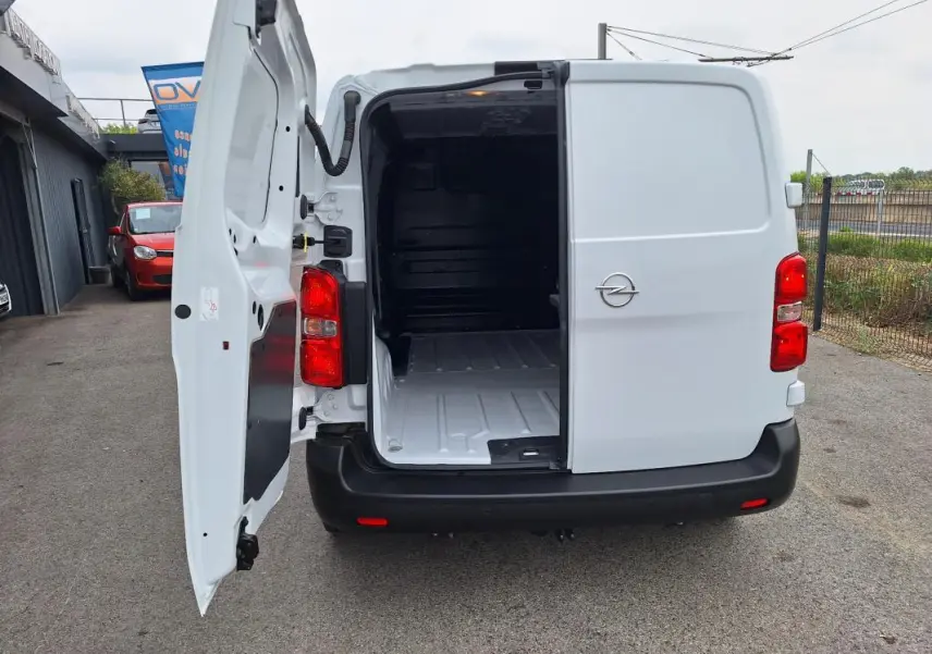 Vue arrière d’un Opel Vivaro blanc 2025 avec porte latérale ouverte montrant l’espace de chargement vide.