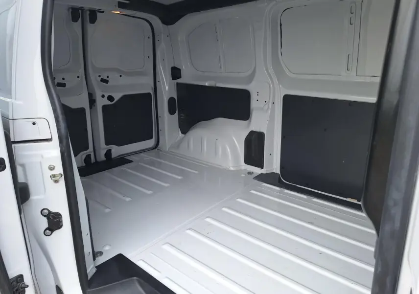 Vue intérieure du fourgon blanc Opel Vivaro 2025, montrant l'espace de chargement vide avec porte latérale ouverte.