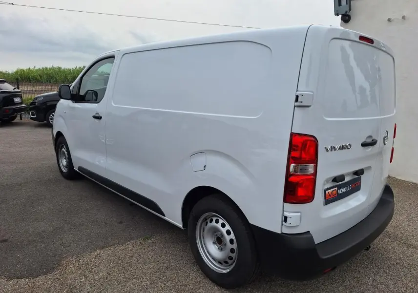 Vue 3/4 arrière droite d’un Opel Vivaro blanc utilitaire avec porte latérale et feux arrière rouges.