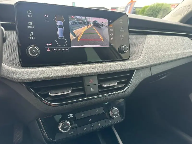 Vue intérieure du tableau de bord de la Skoda Scala blanc cristal, avec écran tactile affichant la caméra de recul.