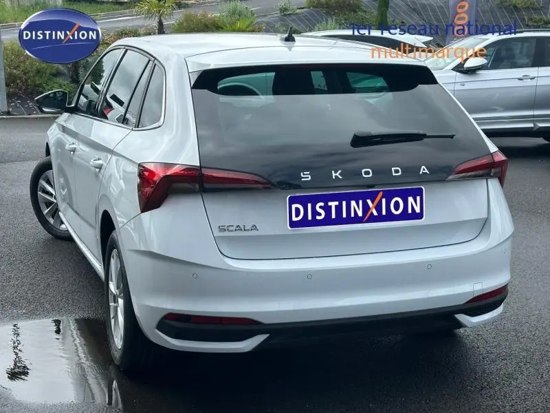 Vue 3/4 arrière gauche d'une Skoda Scala blanc cristal avec feux arrière LED et jantes alu.