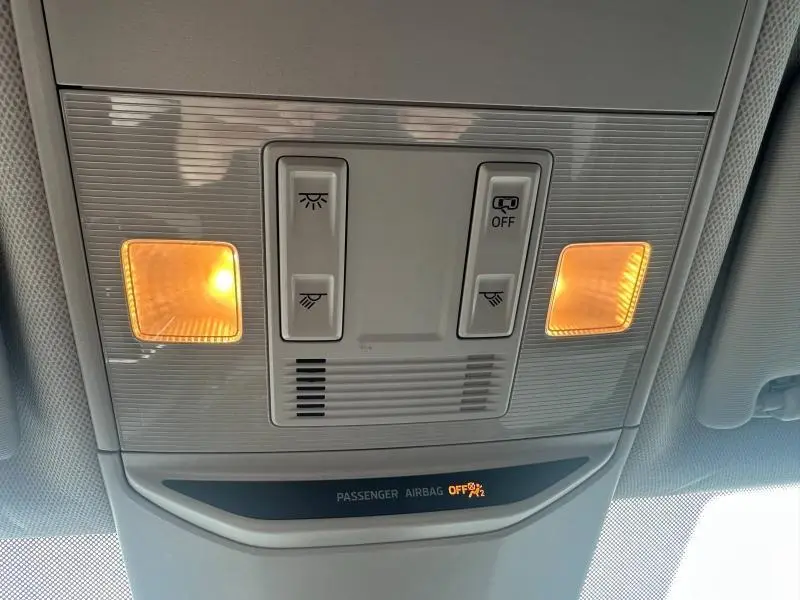Vue en contre-plongée du plafonnier gris clair avec éclairages orange et témoin airbag passager désactivé dans Skoda Scala blanc.