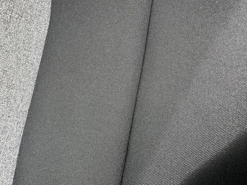 Détail du tissu gris foncé recyclé du siège avant d'une Skoda Scala 2025 blanc cristal.