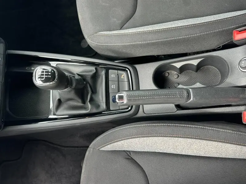 Vue plongeante sur la console centrale de la Skoda Scala blanche, montrant levier de vitesse manuel et frein à main cuir.