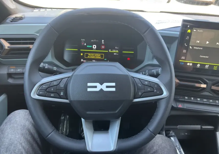 Vue rapprochée du volant cuir noir et du tableau de bord numérique du Dacia Duster Hybrid-G 150 4x4 Extreme City 2026.