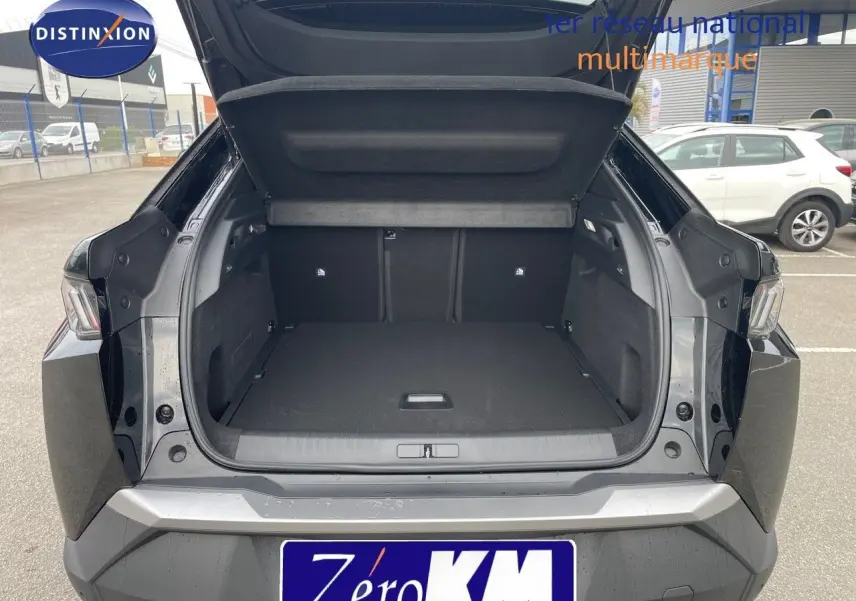 Coffre ouvert d'un Peugeot 3008 Hybrid noir métal vu de l'arrière, montrant un espace de chargement spacieux et propre.