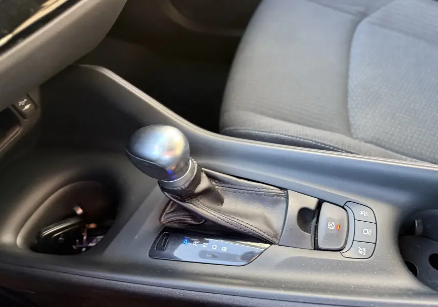 Gros plan sur la console centrale du Toyota C-HR bleu Nebula 2018, montrant le levier de vitesses automatique et les commandes adjacentes.
