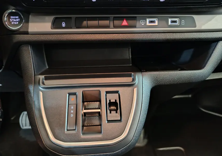 Vue rapprochée de la console centrale noire du Citroën Jumpy 2025 avec boutons de boîte auto et ports USB visibles.