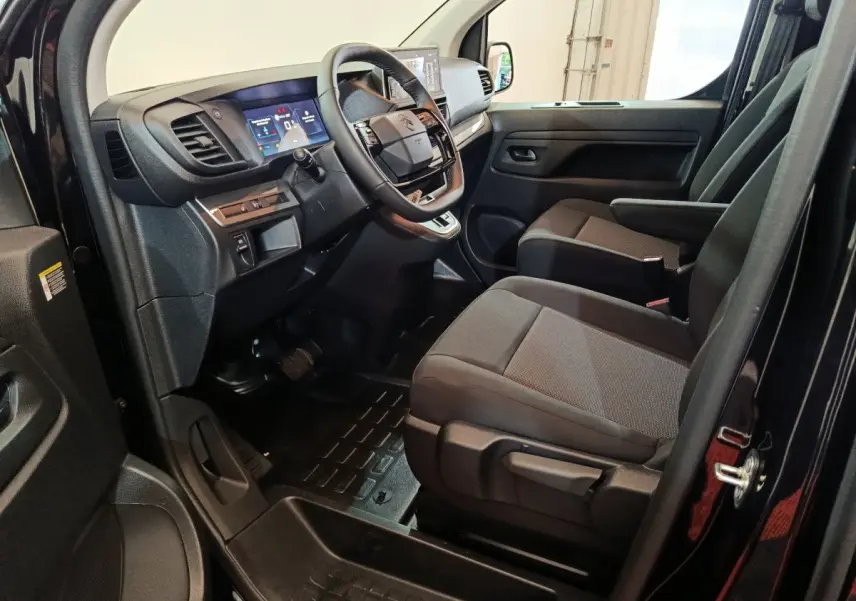 Vue intérieure côté conducteur du Citroën Jumpy XL noir 2025, montrant le tableau de bord et les sièges avant.