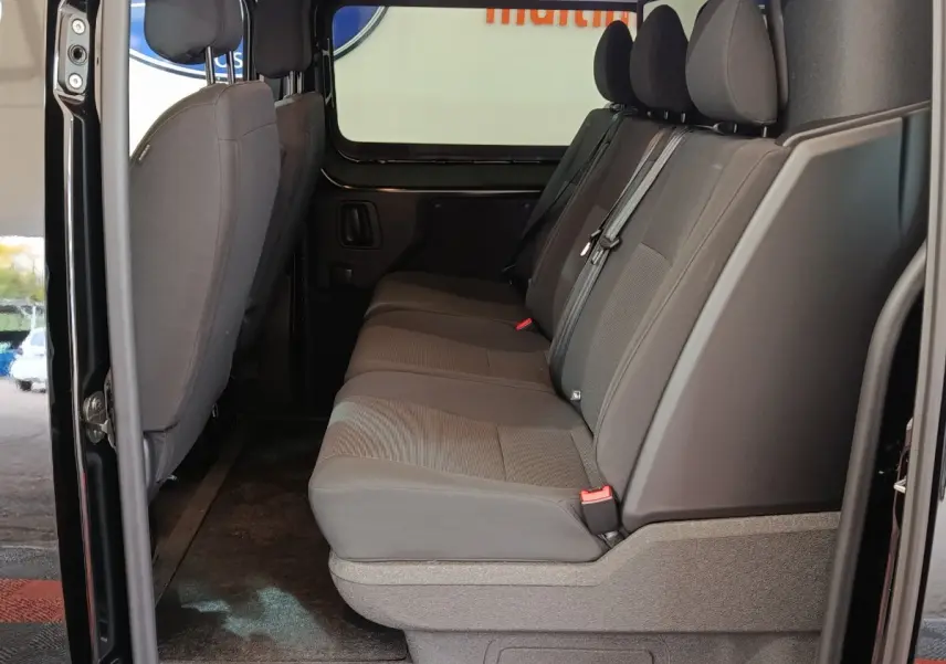 Vue latérale intérieure de la banquette arrière grise du Citroën Jumpy XL noir avec portes ouvertes.