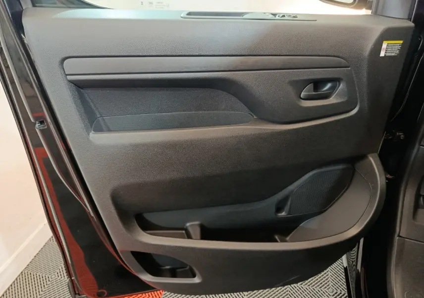 Gros plan sur la porte intérieure côté gauche du Citroën Jumpy XL noir, montrant la poignée et les rangements intégrés.