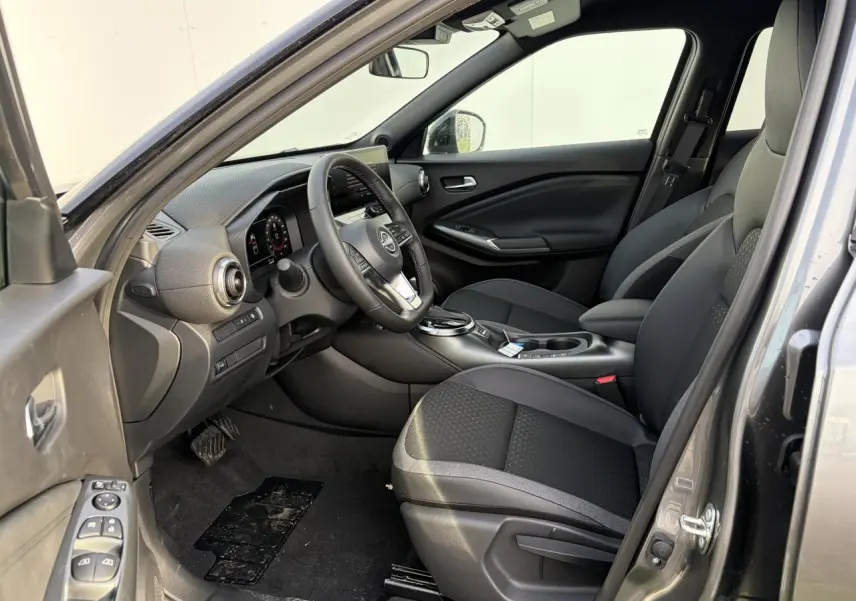 Intérieur noir du Nissan Juke 2 1.6 Hybrid 2025 vu côté conducteur, avec volant cuir et console centrale moderne.