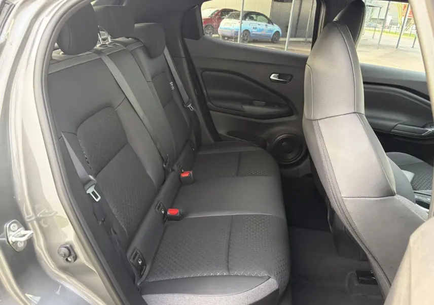 Vue intérieure côté gauche montrant la banquette arrière noire et les sièges avant du Nissan Juke II 1.6 Hybrid N-Connecta.