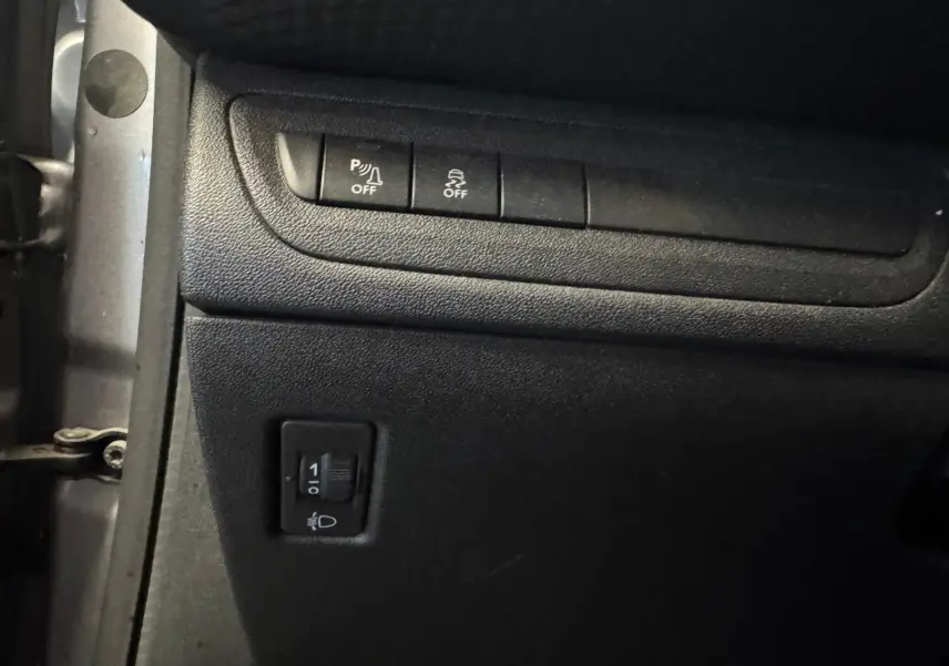 Vue rapprochée du tableau de bord noir du Peugeot 2008 1.6 HDI 100 STYLE, montrant les boutons de contrôle d'ABS et ESP.