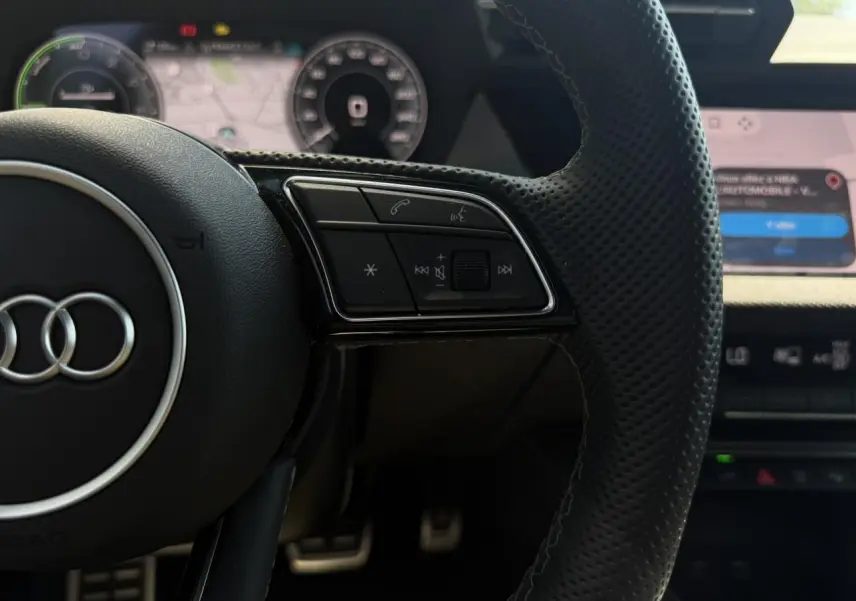 Gros plan sur le volant en cuir perforé noir avec commandes multifonctions de l'Audi A3 Sportback 2025.