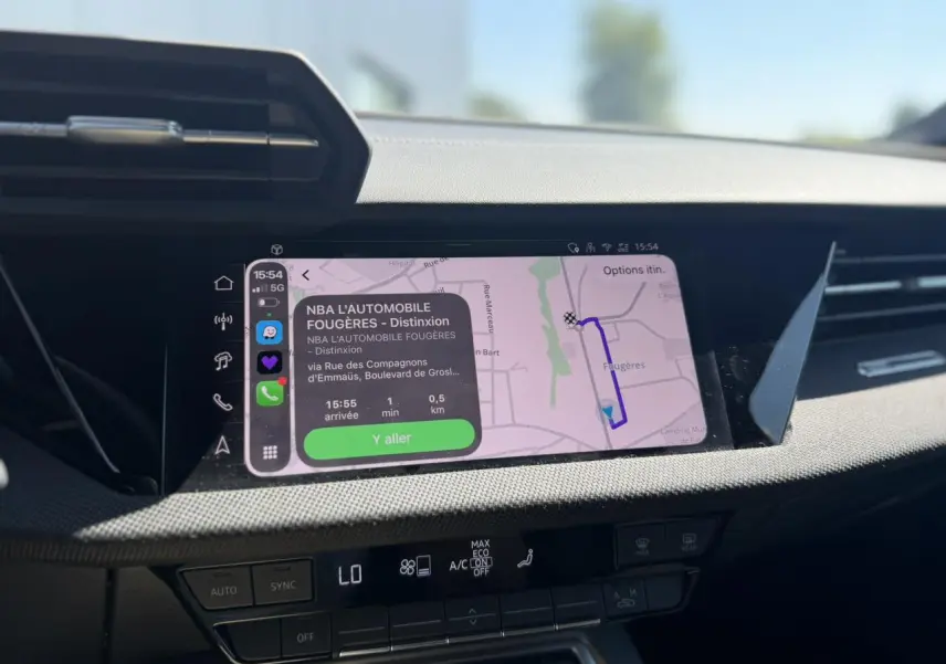 Écran tactile central de l'Audi A3 Sportback noir Mythe, affichant la navigation avec interface moderne et commandes climatisation.