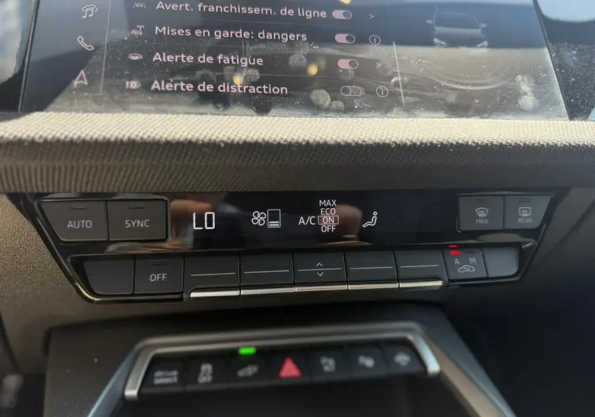 Gros plan sur la console centrale de l’Audi A3 Sportback 2025, affichage climatisation et commandes tactiles noires.