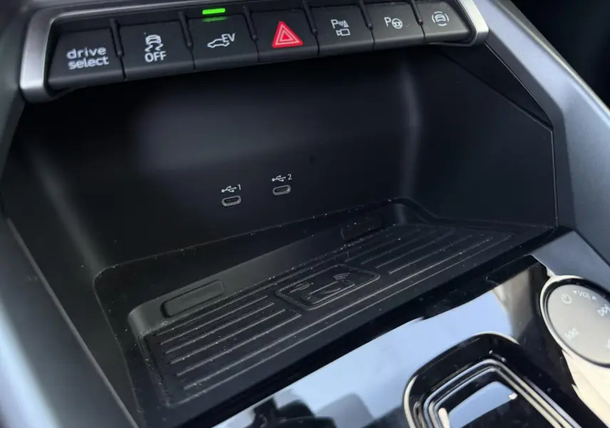 Gros plan sur la console centrale noire de l'Audi A3 Sportback 2025 avec boutons de contrôle et ports USB-C visibles.