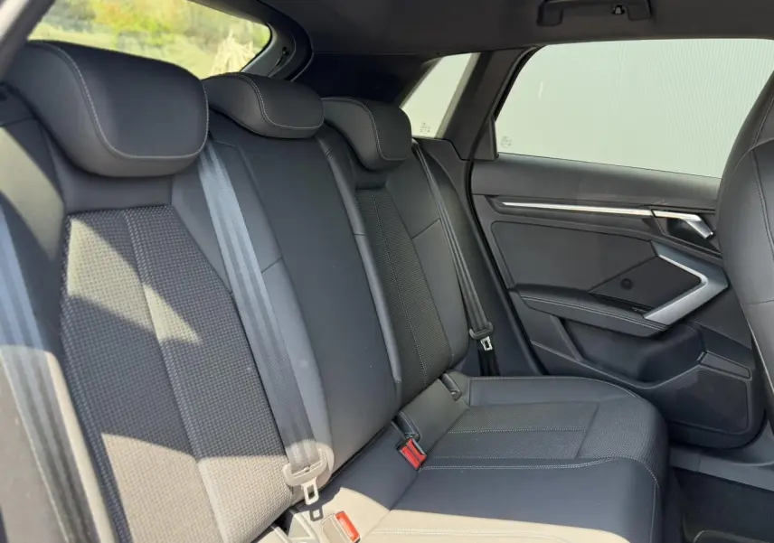 Vue latérale droite de la banquette arrière noire avec ceintures et garnitures tissu et cuir dans l'Audi A3 Sportback 2025.