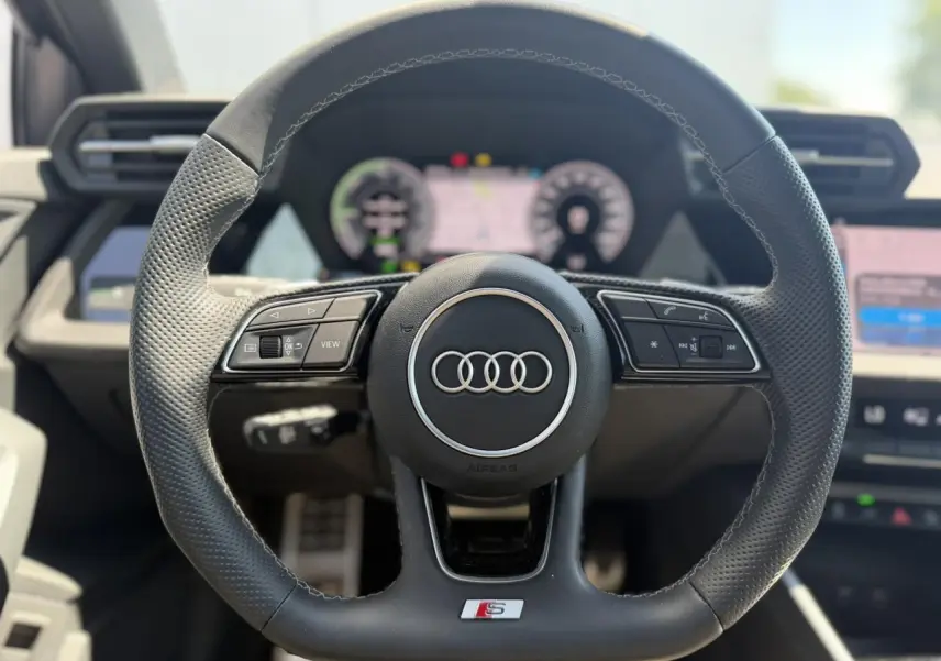 Volant sport en cuir perforé avec logo S et commandes multifonctions, intérieur Audi A3 Sportback 2025 noir Mythe.