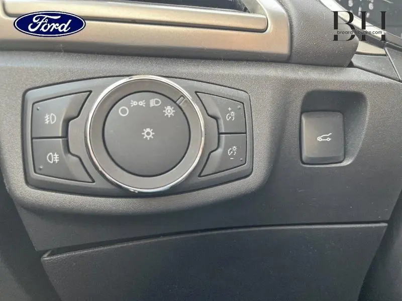 Gros plan sur le bouton de commande des phares et l'ouverture du coffre dans l'habitacle d'une Ford Mondeo gris Magnetic.
