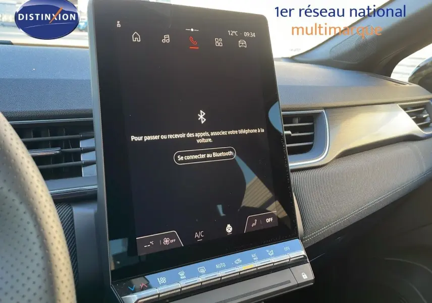 Vue intérieure du tableau de bord du Renault Captur E-Tech hybride 2025, avec écran tactile central allumé et volant partiel visible.