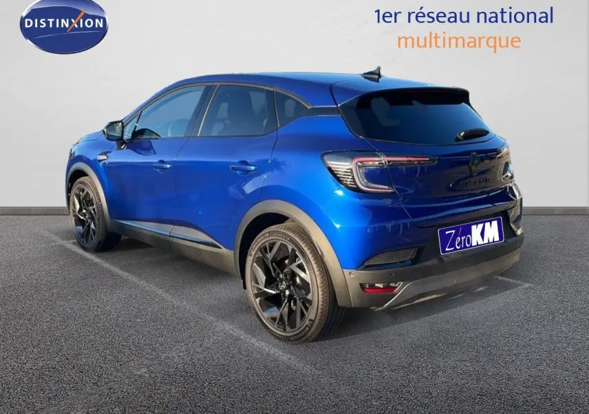 Vue 3/4 arrière droite d'un Renault Captur E-Tech hybride bleu Iron Metal avec toit noir et jantes noires.