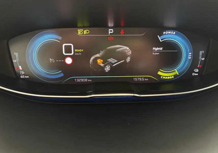 Affichage numérique du tableau de bord du Peugeot 3008 hybride, montrant l'état de charge et la consommation.
