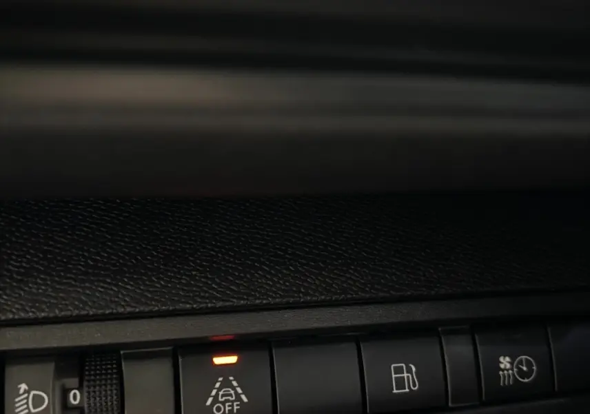 Gros plan sur les commandes du tableau de bord du Peugeot 3008 gris foncé, avec témoin d'alerte de maintien de voie éteint.