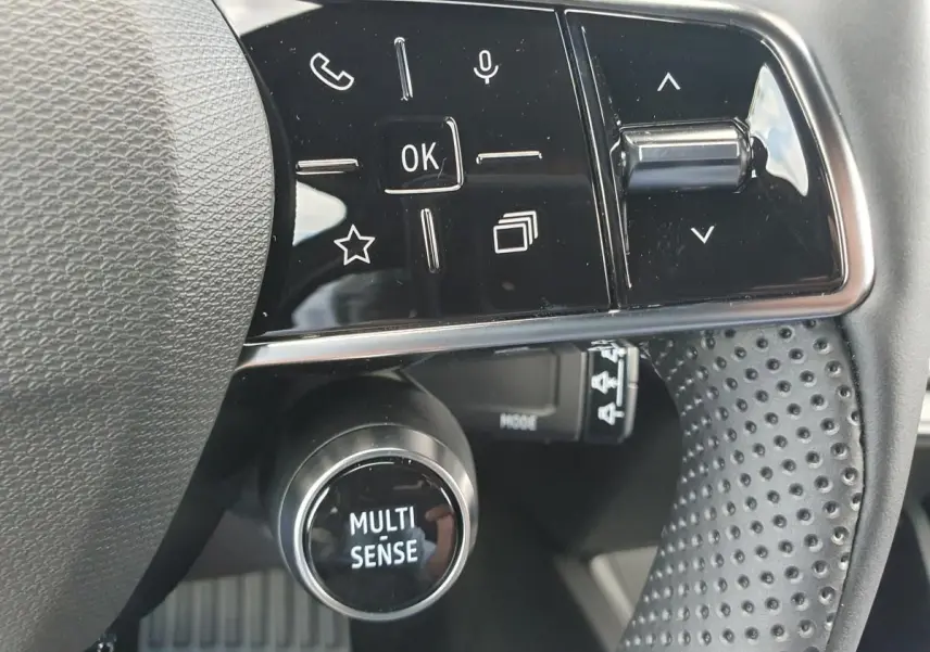 Gros plan sur le volant noir perforé de la Renault Clio VI avec commandes multifonctions et bouton MULTI-SENSE.