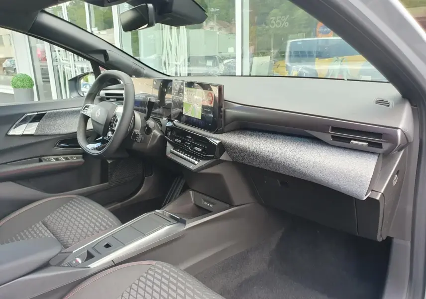 Vue intérieure côté passager de la Renault Clio VI avec tableau de bord moderne et écran tactile central.