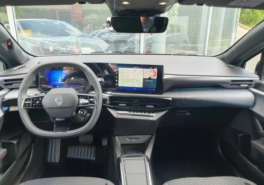 Vue intérieure avant de la Renault Clio VI avec tableau de bord numérique et écran tactile central.