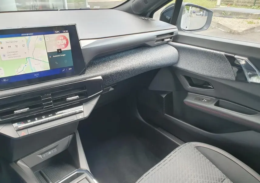 Vue intérieure côté passager de la Renault Clio VI 2026, tableau de bord moderne avec écran tactile et garniture grise texturée.