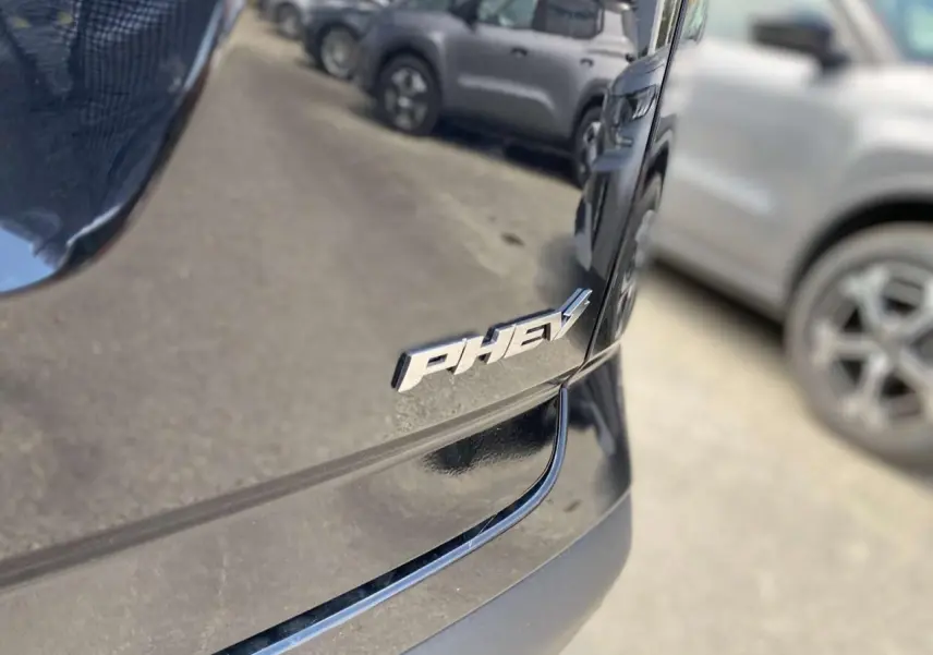 Gros plan sur l'arrière droit noir carbone brillant du JAECOO J7 1.5 PHEV avec le badge "PHEV" visible.