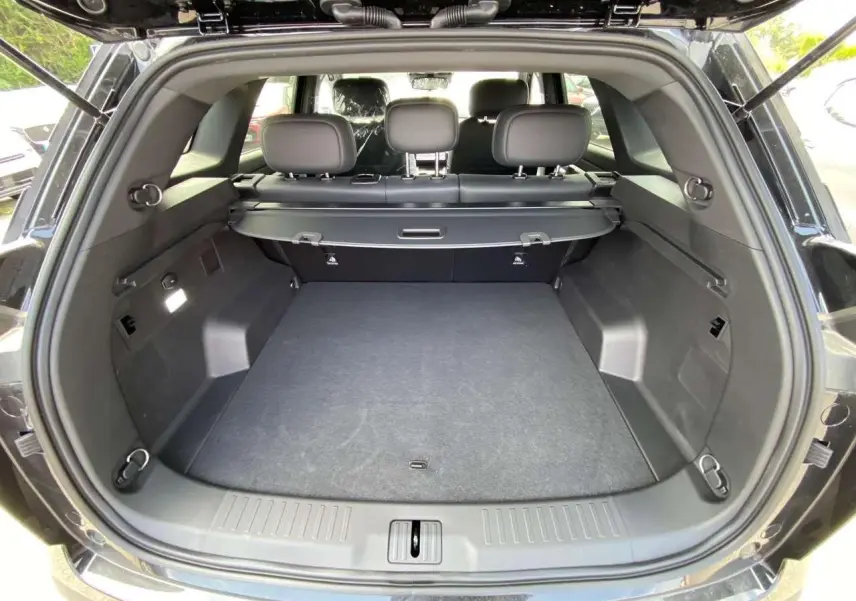 Coffre ouvert du JAECOO J7 1.5 PHEV Selective 2026 en carbone cristal noir, montrant un espace de chargement spacieux et propre.