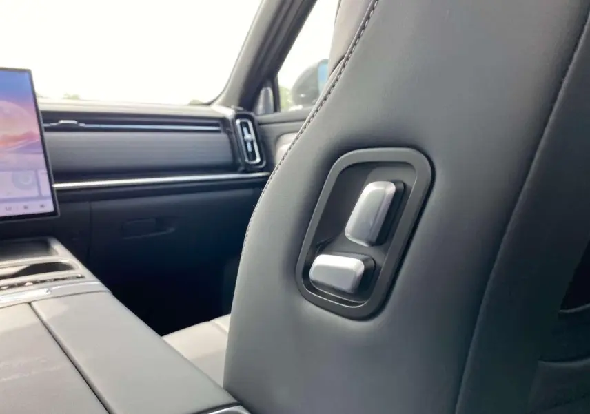 Vue intérieure rapprochée du siège avant droit du JAECOO J7 2026 en cuir noir avec commandes de réglage intégrées.