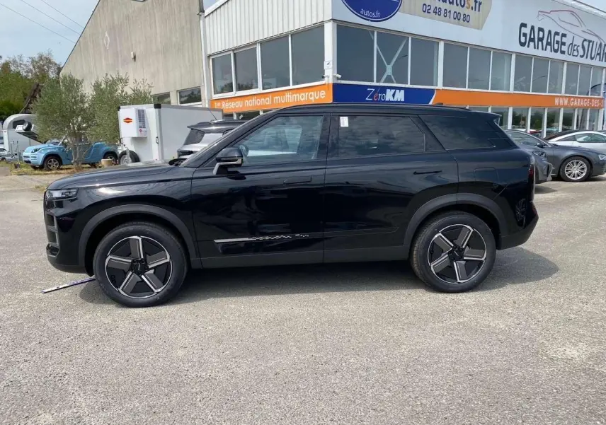 Vue de profil côté gauche du JAECOO J7 2026 en noir Carbon Cristal, avec ses jantes au design moderne et carrosserie lisse.