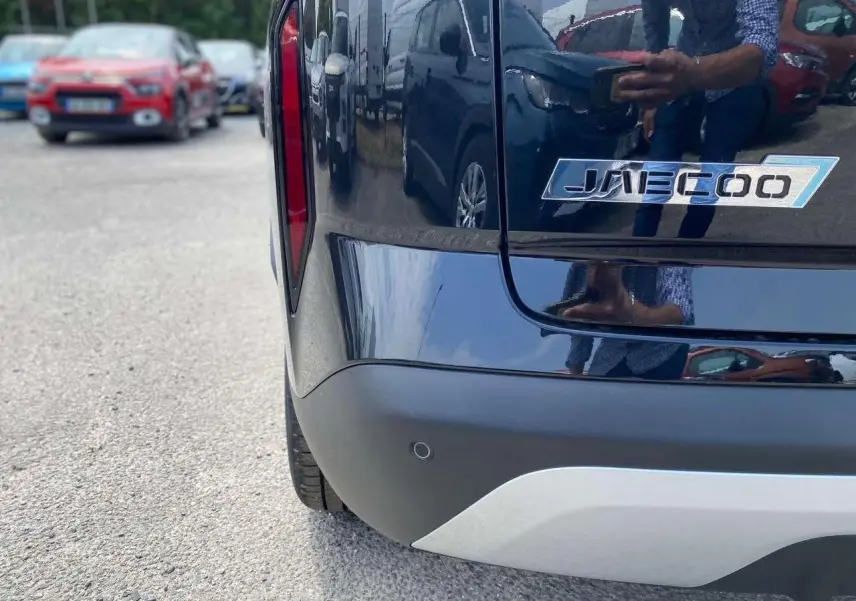 Gros plan sur l’arrière droit noir brillant du JAECOO J7 1.5 PHEV avec logo distinctif et feu arrière vertical rouge.