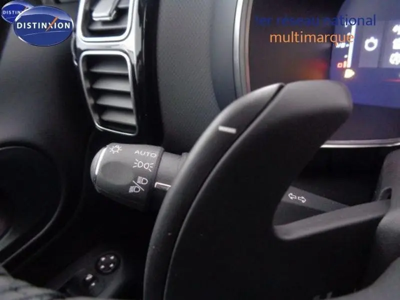 Gros plan sur la manette des phares à gauche du volant dans l'habitacle noir du Citroën C5 Aircross 2022.