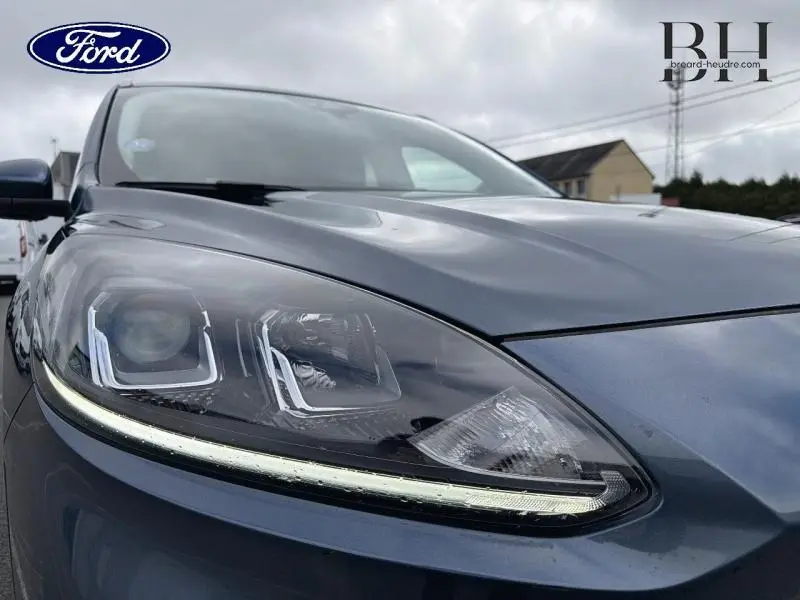 Gros plan sur le phare avant gauche du Ford Kuga 2022 bleu azur métallisé avec éclairage LED distinctif.