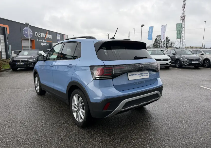 Volkswagen T-Cross bleu vue 3/4 arrière droit, avec jantes alliage et vitres arrière surteintées.
