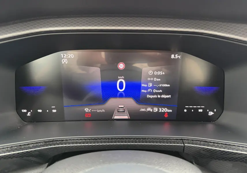 Combiné d'instruments digital du Volkswagen T-Cross 2025 affichant vitesse, autonomie et alertes, vue frontale rapprochée.