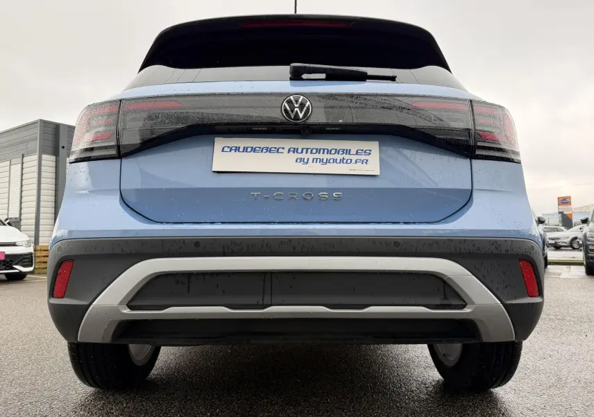 Vue arrière d'un Volkswagen T-Cross bleu 2025 avec feux LED et pare-chocs noir et gris contrasté.