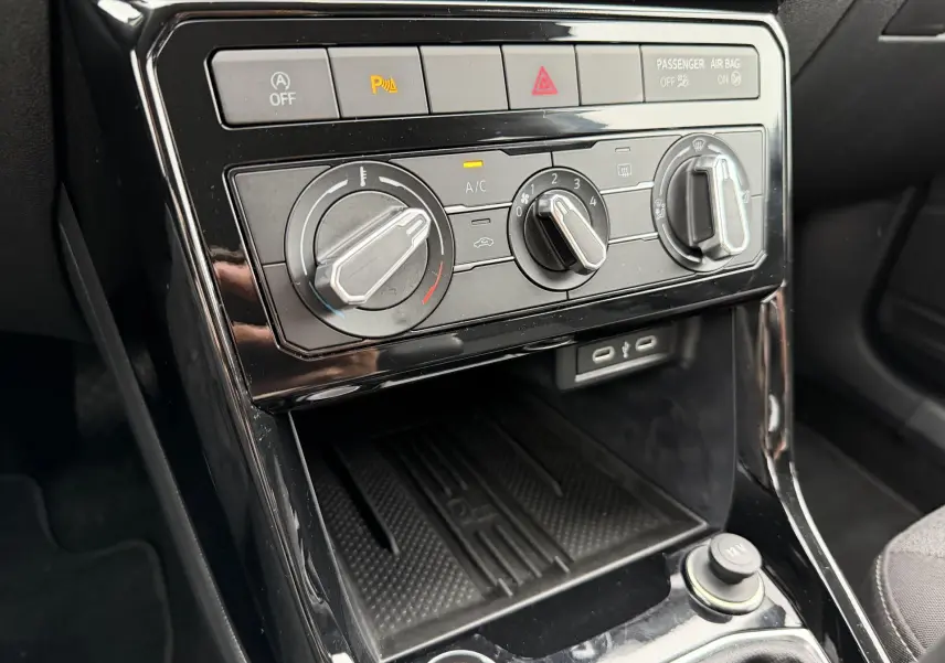 Vue rapprochée de la console centrale du Volkswagen T-Cross 2025, montrant les commandes de climatisation manuelle.
