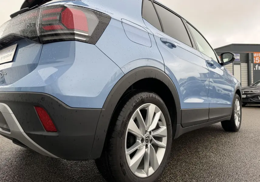 Vue 3/4 arrière droite du Volkswagen T-Cross bleu 2025 avec jantes alliage Bangalore et feux LED distinctifs.