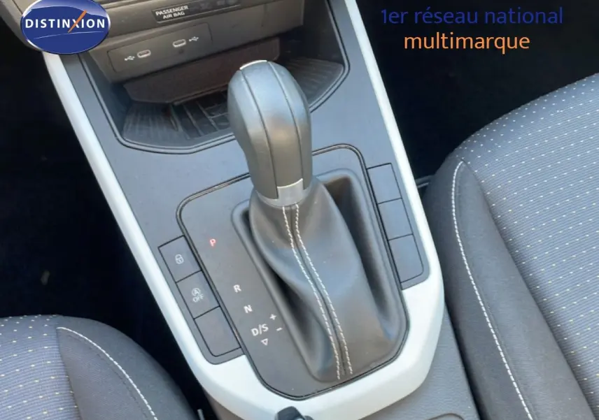 Le levier de vitesses automatique en cuir noir avec surpiqûres blanches dans l'habitacle du SEAT Arona 2025.