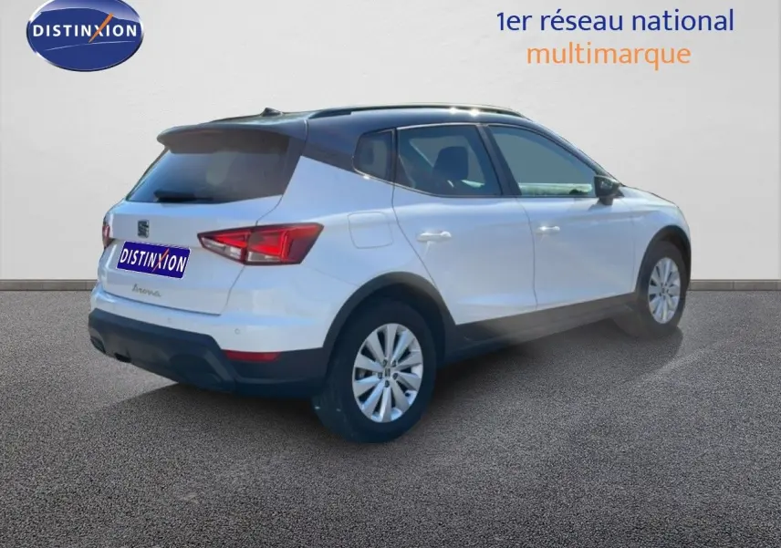 SEAT Arona blanc métal avec toit noir vu en 3/4 arrière droit sur fond neutre extérieur.