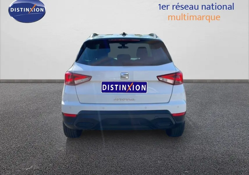 Vue arrière d'un SEAT Arona blanc métal avec toit noir, version Style Special Edition 2025, garé sur sol gris.