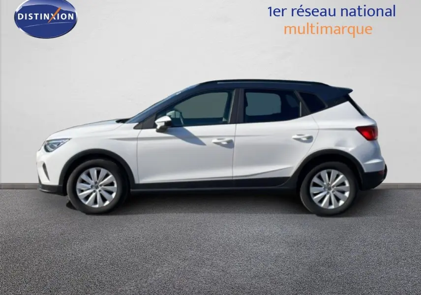 Vue latérale gauche d'un SEAT Arona blanc métal avec toit noir, jantes alliage et détails noirs sur bas de caisse.
