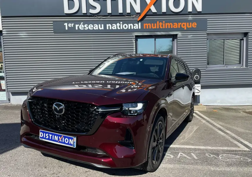 Vue 3/4 avant du Mazda CX-80 Artisan Red 2024, hybride rechargeable, avec calandre noire et jantes foncées.